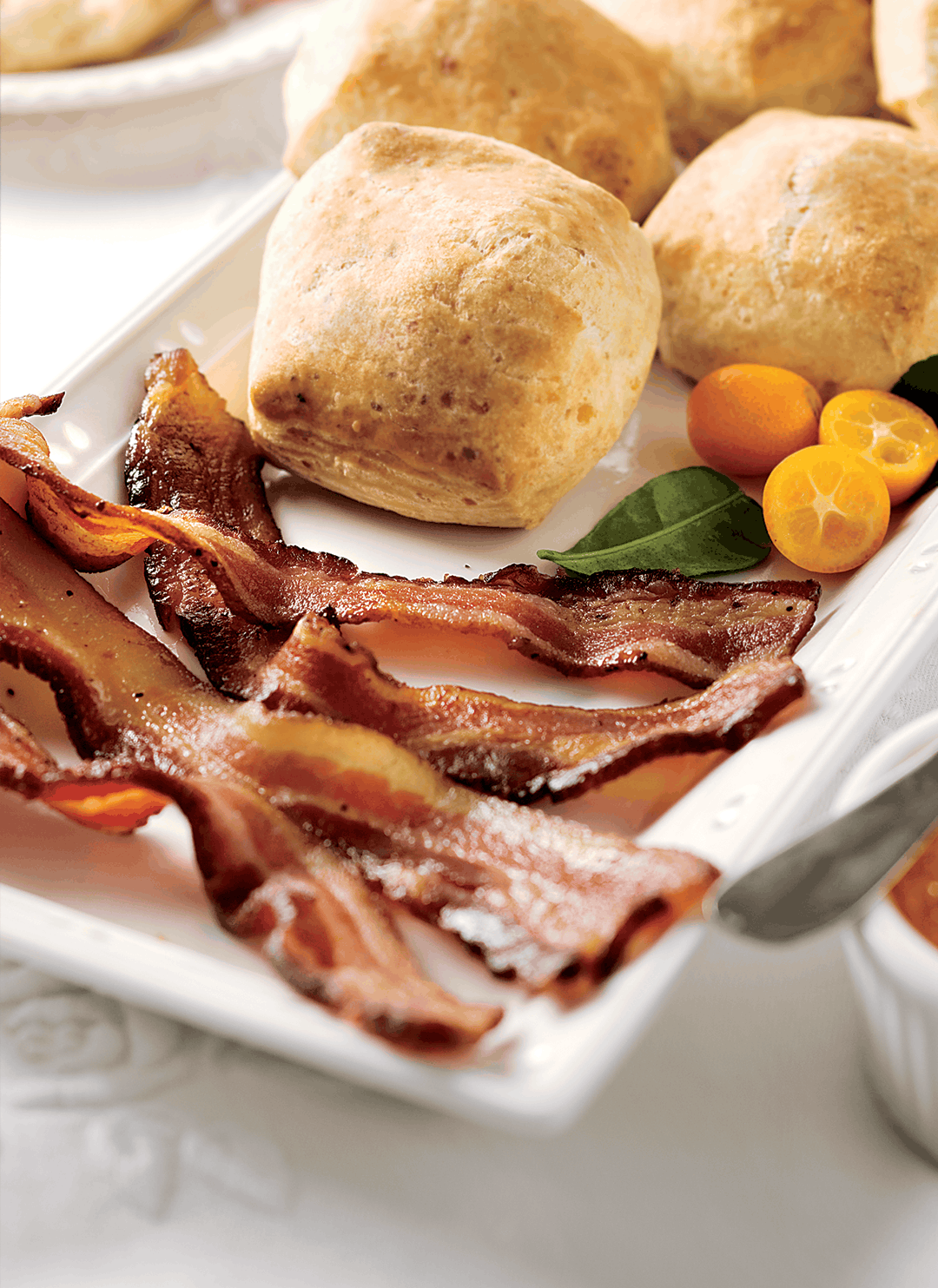 Classic sliced bacon on a tray with fresh rolls