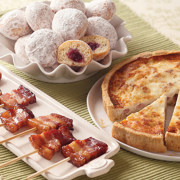 Brunch Favorites Sampler, featuring Fruit-Filled French Beignets (top), Vanilla-Bourbon Bacon "Lollipops" (bottom left), and Quiche Lorraine (bottom right).
